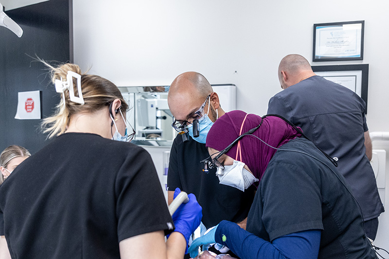 3 dentists working on a patient.